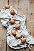 Frische Eier auf gestreiftem Tuch