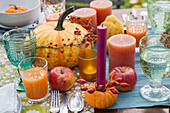 Autumnal table setting with pumpkins, apples and candles