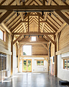 Sunlight in renovated barn with wooden beams and concrete floor