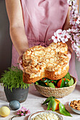 Hands holding Colomba (traditional Italian Easter cake with almonds)