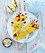 Crêpes filled with baked apple, sultanas and nuts