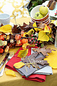 Herbstliche Tischdekoration mit Laub und Lampionblumen