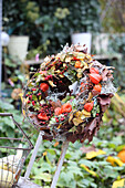 Autumnal door wreath made of physalis, barbed wire plant, hydrangea, hawthorn berries and foliage