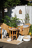 Korbsessel mit Tisch und Teppich auf Terrasse, Accessoires mit DIY-Verzierung