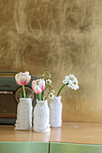 Tulips and waxflowers in bottles wrapped in waxed paper and silver wire