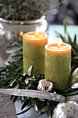 Christmas arrangement with green candles, silver baubles and wreath on olive branches