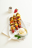 Fruit skewers with brioche bread and chocolate sauce, served with vanilla ice cream