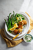 Fiscakes with wilted letce and peas cooked in butter, asparagus and tartare sauce