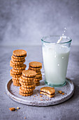 A plate of chocolate-filled cookies and a glass of milk