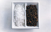 Coarse salt and black peppercorns in a bowl