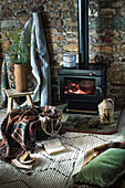 Wood-burning stove in cosy living room with natural stone wall