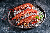 Shrimps in bowl with ice and parsley placed on black table in luxury restaurant