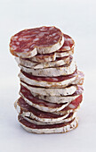 Stacked salami slices on a light background