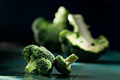 Broccoliröschen, im Hintergrund ganzer und halber Broccoli