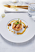 Salmon strips on bulgur on a festive white plate with golden accents