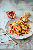 Couscous salad with quail breast, grilled peppers, and pomegranate seeds