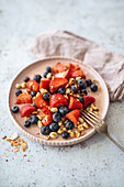 Fruit salad with blueberries, strawberries, peanuts, and coconut flakes (low carb, vegan)