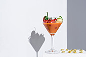 Gazpacho mit Tomaten und Gurke, serviert im Cocktailglas, daneben Vitaminkapseln