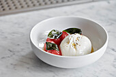 Burrata served with balls of watermelon and drizzled with olive oil