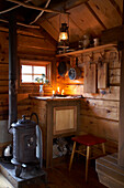 Wood burning stove with storage cupboard in hunting cabin in Svartadalen, Sweden
