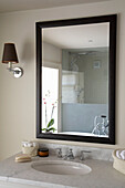 Spiegel mit schwarzem Rahmen über Waschbecken im Badezimmer in Rye, Sussex