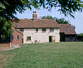 Exterior shot of a country house with converted barn extension and garden