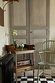 Period spindleback chair next to wooden table in front of built in cupboard