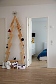 Christmas tree built from wooden planks next to bedroom door