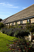 Stone house exterior in the Cotswolds plants in garden by stone wall