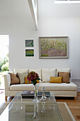 White sofa with artwork and glass topped table