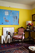Modernes Kunstwerk in gelbem Raum mit gemustertem Teppich