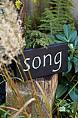 Garden ornament with the work 'song' in Brighton garden, Sussex, UK