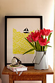 Cut tulips on side table with alarm clock and artwork in Richmond upon Thames, England, UK