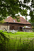 Sonnenliegen auf dem Rasen eines Hauses in West Sussex, England, UK