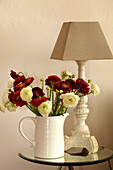 Jug of cut flowers on mirrored side table in Brighton home, East Sussex, England, UK