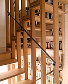 Detail of a modern wooden staircase with inbuilt book shelves underneath