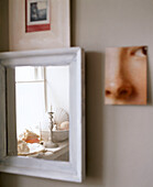 Reflection of ornaments on window sill in white wood mirror