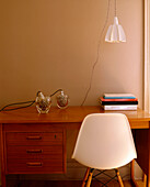 A detail of a modern desk retro chair hanging lamp