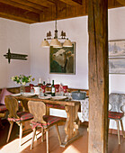 A country dining room with beam posts and timber ceiling wood table and chairs table setting chandelier