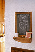 A detail of a rustic country kitchen wooden chalkboard