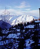 Ein Blick auf das Skigebiet von Verbier mit Chalets und schneebedeckten Bergen in der Ferne