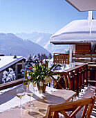 Exterior of Swiss chalet with glasses of wine on table on balcony