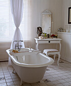 Freestanding roll top bath in centre of country style bathroom