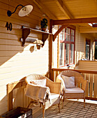 Wicker chairs on covered veranda of timber house