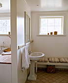 Pedestal washbasin next to seat below window