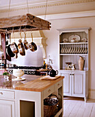 Saucepans hanging in kitchen with freestanding dresser