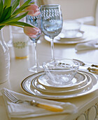 Dining table setting with blue glass bone handled cutlery and china plates