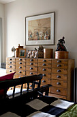 Old fashioned shop chest of drawers displaying a variety of objects in bedroom