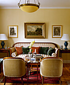 Traditionelles gelbes Wohnzimmer mit antikem Sofa, Sesseln und Beistelltischen