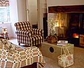 Upholstered armchair next to inglenook fireplace